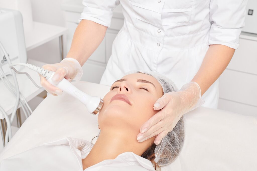 Beautician makes ultrasound skin tightening for rejuvenation woman face using phonophoresis